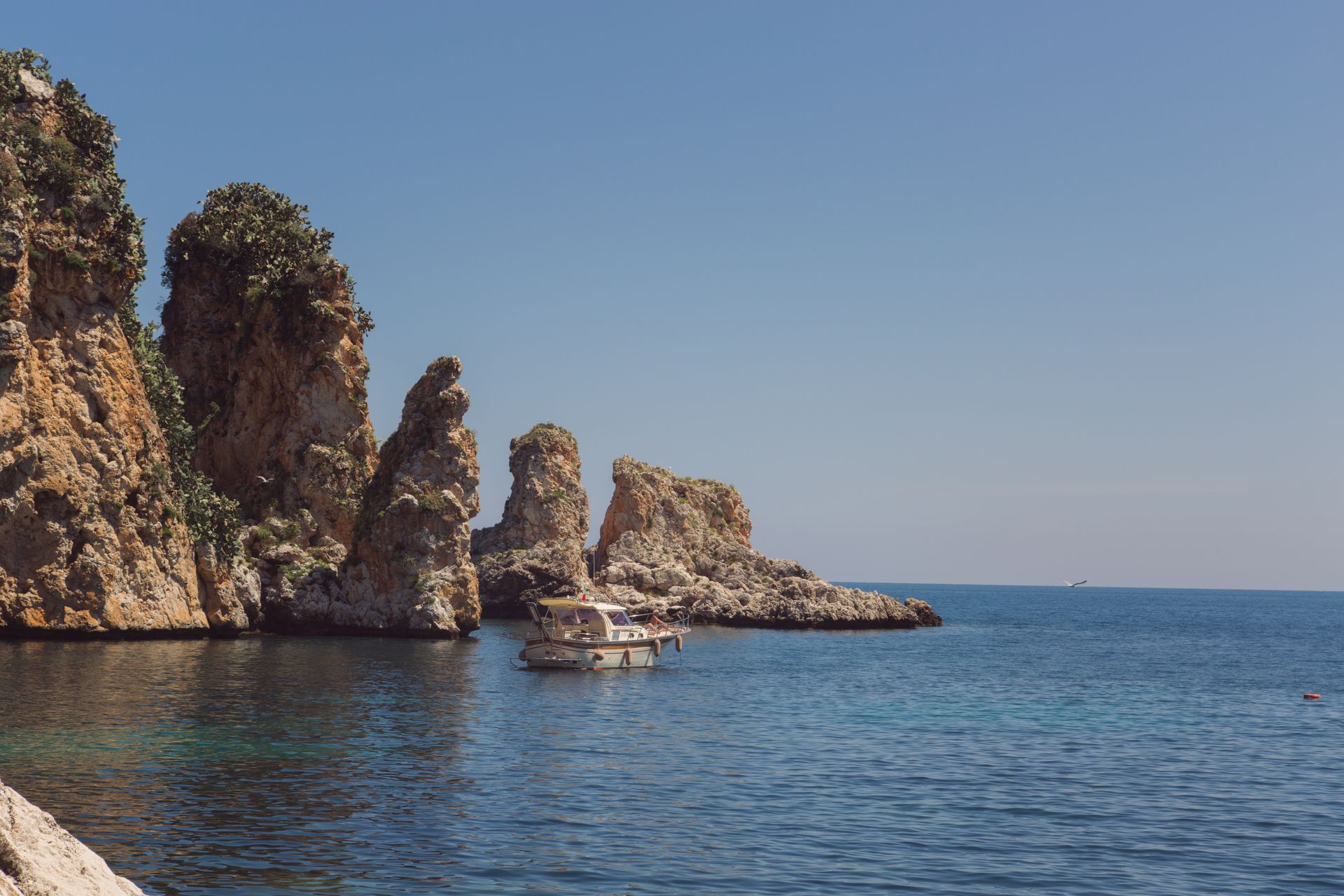 I faraglioni di Scopello e una barca sul mare