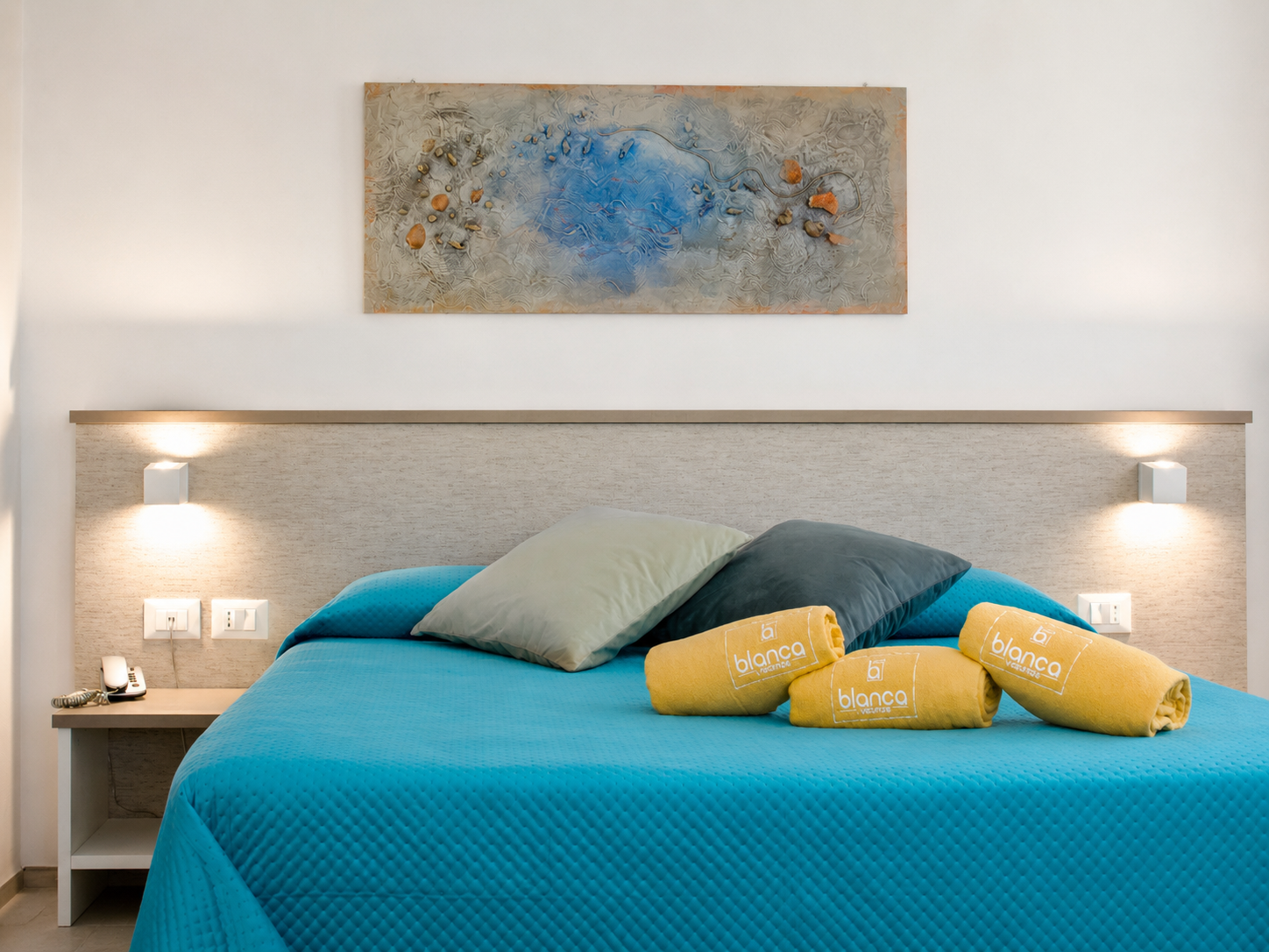 Doppelbett mit gelben La Blanca-Handtüchern